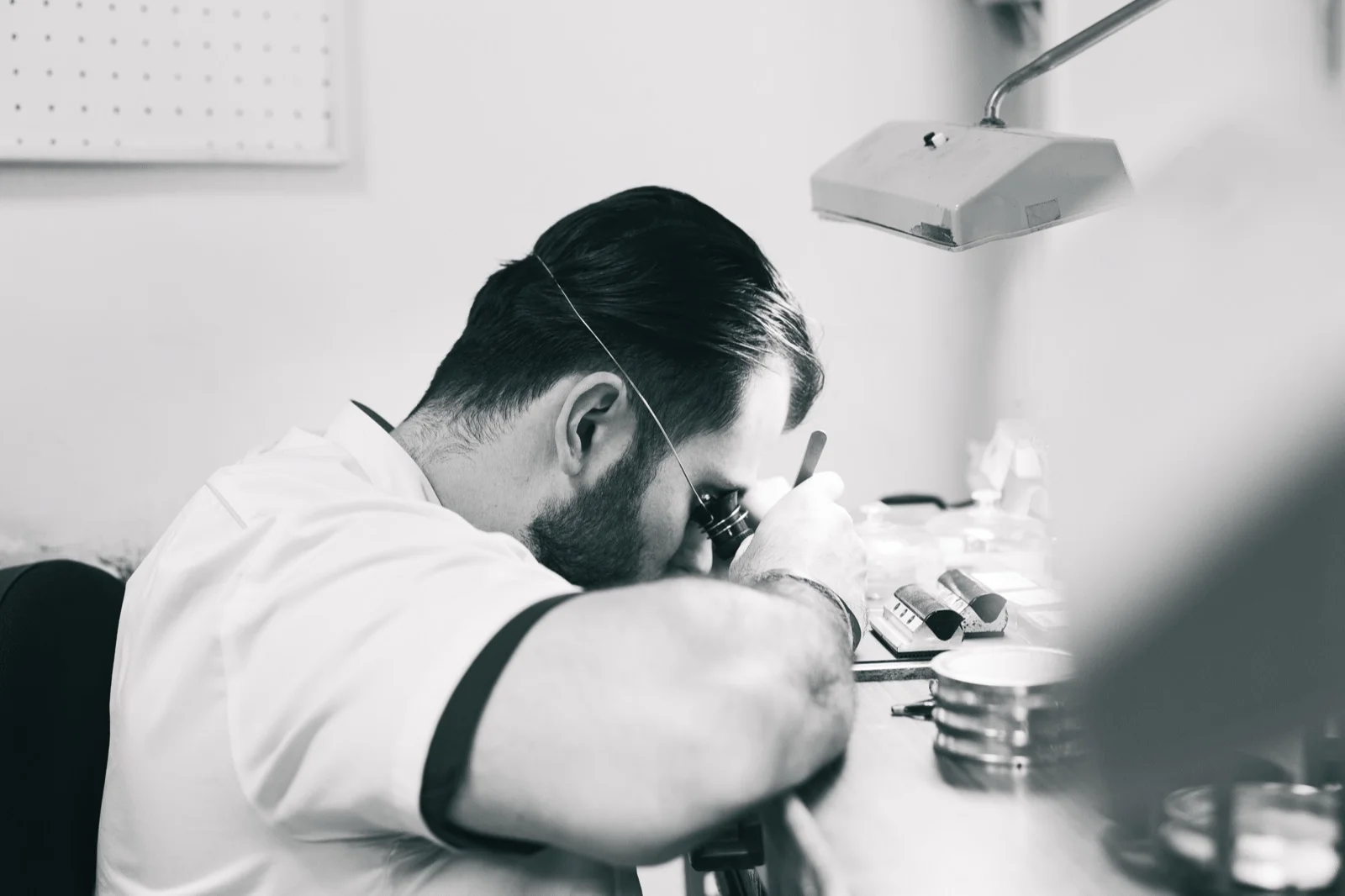 Artisan horloger au travail à la loupe sur son établi