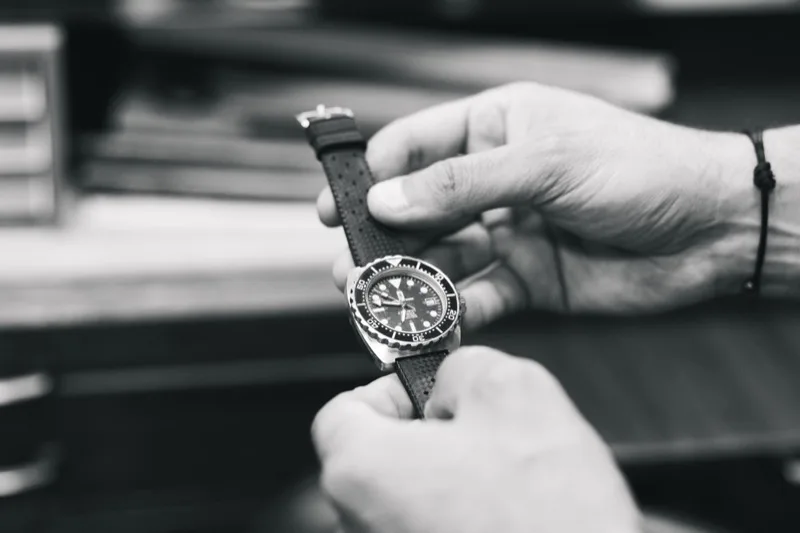 Contrôle d'une montre de plongée entre les mains d'un horloger à l'atelier Jacques Bianchi
