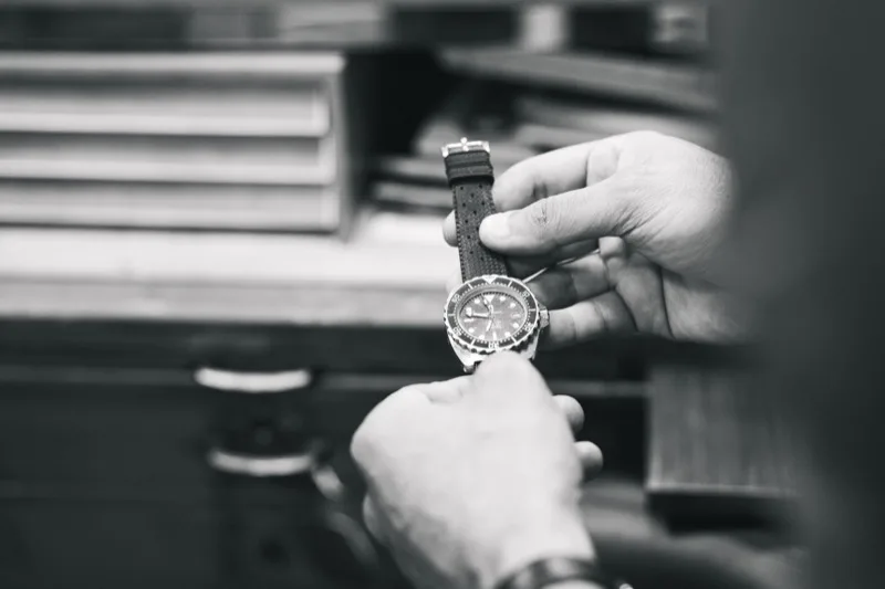 Inspection minutieuse d'une montre de plongée par un artisan horloger marseillais